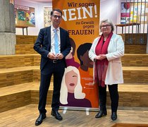 Der hessische Justizminister Christian Heinz steht gemeinsam mit Hochschulpräsidentin Prof. Dr. Eva Waller vor einem Roll-up des Frauen- und Gleichstellungsbüros der Hochschule RheinMain.