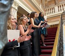 Absolvent:innen des Fachbereichs Wiesbaden Business School stehen mit ihren Urkunden auf einer Treppe.