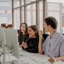 Students sitting at desks and looking at computer monitors 