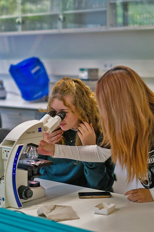Technikantinnen beim Mikroskopieren während des Laborrundgangs.