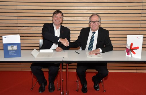 Prof. Dr. Detlev Reymann, Präsident der Hochschule RheinMain (li.), und Joachim Nolde, Hauptgeschäftsführer der IHK Wiesbaden, unterzeichnen die Kooperationsvereinbarung.