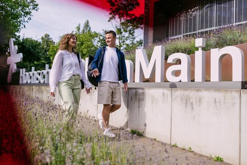 Studierende laufen vor dem G-Gebäude