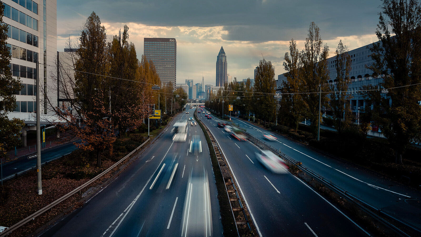 Straße zum Europaviertel in Frankfurt vierspurige Straße mit Hochhäusern und dem Messeturm Frankfurt im Hintergrund