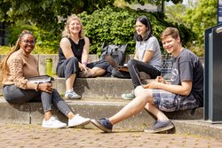 Studierende der Hochschule RheinMain sitzend auf einer Treppe