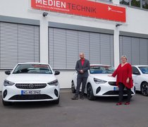 Prof. Dr. Eva Waller, Präsidentin der Hochschule RheinMain, und Dr. Martin Lommel, Kanzler der Hochschule RheinMain mit den neuen E-Fahrzeugen auf dem Campus Unter den Eichen.