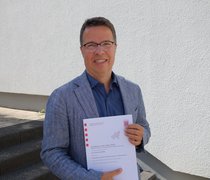 Prof. Roman-Müller mit der Urkunde des HMWK © Hochschulkommunikation | Hochschule RheinMain 