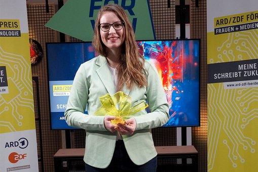 Maike Kaiser hält die Siegerinnen-Trophäe des ARD/ZDF Förderpreises „Frauen + Medientechnologie“ in den Händen.