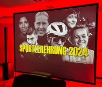 Blick auf die Leinwand mit einer Collage von Spitzensportler:innen der Hessischen Hochschule für öffentliches Management und Sicherheit und der Hochschule RheinMain, darüber der Text „Sportlerempfang 2024“