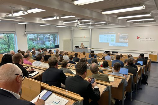 Blick in einen voll besetzen Hörsaal der Hochschule RheinMain während eines Vortrags auf dem 10. Wiesbadener Versicherungskongress