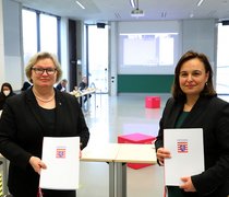 Prof. Dr. Eva Waller (li.) und Staatssekretärin Ayse Asar mit den soeben unterzeichneten Zielvereinbarungen
